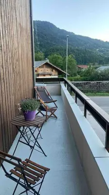 two chairs and a table on a balcony at Appartement 4 personnes centre village in Samoëns