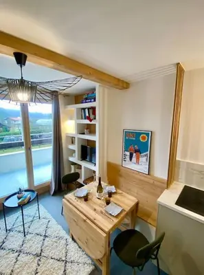 a living room with a table and chairs and a window at Appartement 4 personnes centre village in Samoëns