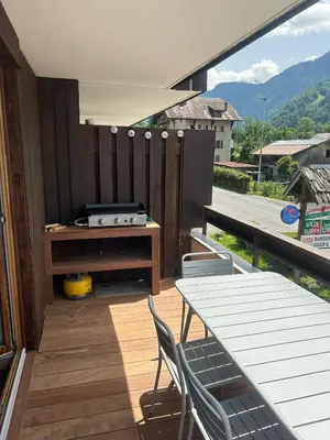 a balcony with a table and chairs and a grill at Appartement 4 personnes centre village in Samoëns