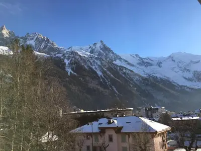 a snow covered mountain with a train in front of it at Chamonix : Appartement 63 m², 6 pers, Confort & Wifi - FR-1-507-78 in Chamonix-Mont-Blanc