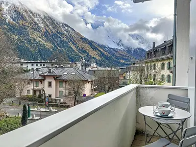 a table and chairs on a balcony with a view of a mountain at Chamonix : Appartement 63 m², 6 pers, Confort & Wifi - FR-1-507-78 in Chamonix-Mont-Blanc