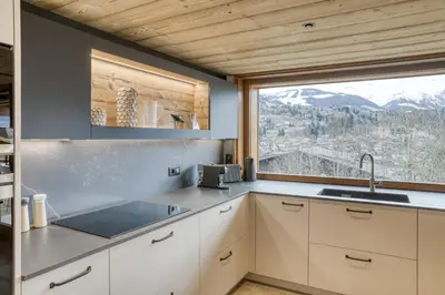 a kitchen with a sink and a large window at Chalet de Denis luxe alpin et emplacement ideal à Megeve in Megève