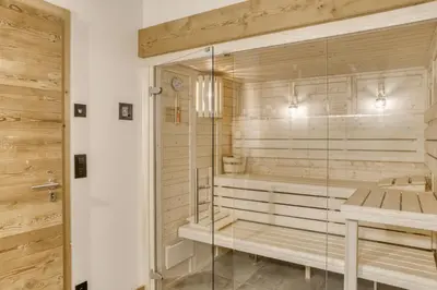 a bathroom with a sauna with a wooden wall at Chalet de Denis luxe alpin et emplacement ideal à Megeve in Megève
