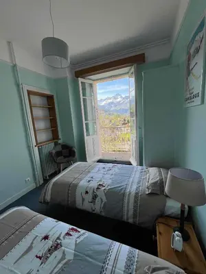 a bedroom with two beds and a window with a view at Appartement vue Mont Blanc in Combloux