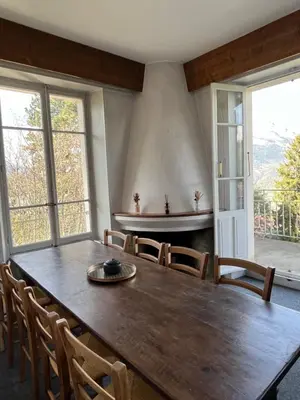 a dining room with a large wooden table and chairs at Appartement vue Mont Blanc in Combloux