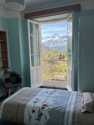 a bedroom with a bed and a large window at Appartement vue Mont Blanc in Combloux