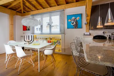 a kitchen and dining room with a white table and chairs at Le Bartavel Apartment - Chamonix All Year in Chamonix-Mont-Blanc