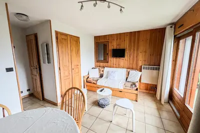 a room with a bed and a table and chairs at Charming T2 in Saint-Gervais-les-Bains in Saint-Gervais-les-Bains