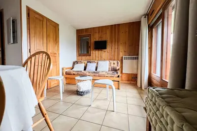 a living room with a couch and a table and chairs at Charming T2 in Saint-Gervais-les-Bains in Saint-Gervais-les-Bains