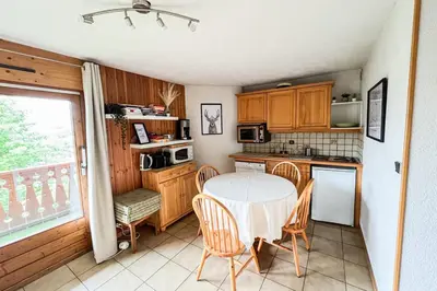 a kitchen with a table and chairs and a window at Charming T2 in Saint-Gervais-les-Bains in Saint-Gervais-les-Bains