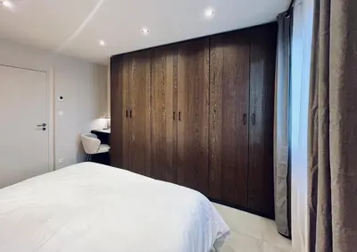 a bedroom with a large bed and wooden cabinets at Les hirondelles in Passy