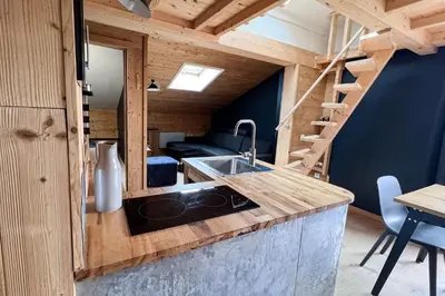 a kitchen with a sink and a staircase in a tiny house at T2 with pool in Saint-Gervais-les-Bains in Saint-Gervais-les-Bains
