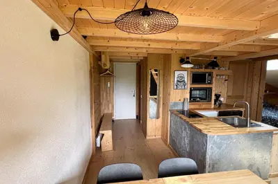 a kitchen with a sink and a counter with chairs at T2 with pool in Saint-Gervais-les-Bains in Saint-Gervais-les-Bains