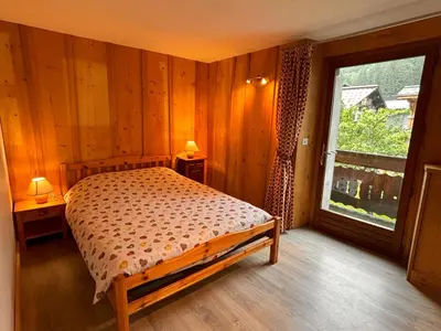 a bedroom with a bed and a large window at Appartement Chamonix in Chamonix-Mont-Blanc