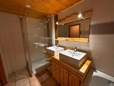 a bathroom with two sinks and a shower at Appartement Chamonix in Chamonix-Mont-Blanc
