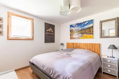 a bedroom with a large bed and a window at Chalet des Morets in Saint-Gervais-les-Bains