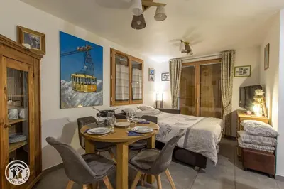 a bedroom with a table and chairs and a bed at Chalet des Morets in Saint-Gervais-les-Bains