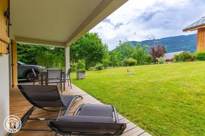 a porch with chairs and a lawn in the background at Chalet des Morets in Saint-Gervais-les-Bains