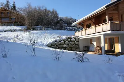 a snow covered yard in front of a house at Chalet des Morets in Saint-Gervais-les-Bains