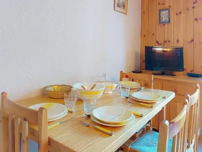 a wooden table with plates and bowls on it at Apartment Isabella by Interhome in Saint-Gervais-les-Bains
