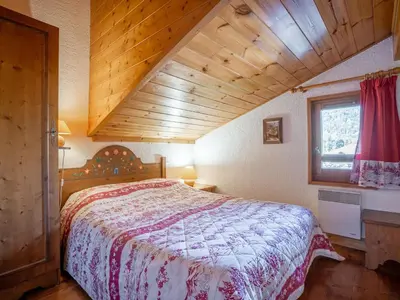a bedroom with a bed and a wooden cabinet at Apartment Les Hauts des Chavants -2 by Interhome in Les Houches