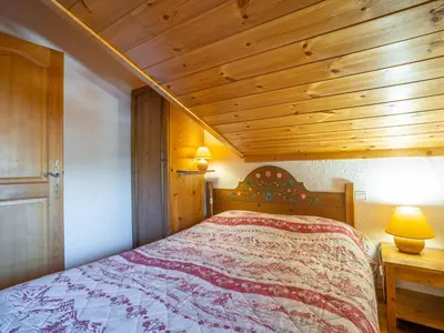 a bedroom with a bed and a wooden ceiling at Apartment Les Hauts des Chavants -2 by Interhome in Les Houches