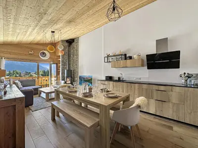 a kitchen and living room with a wooden table and chairs at GR450 6 Pers Centre Carroz in Les Carroz d'Araches
