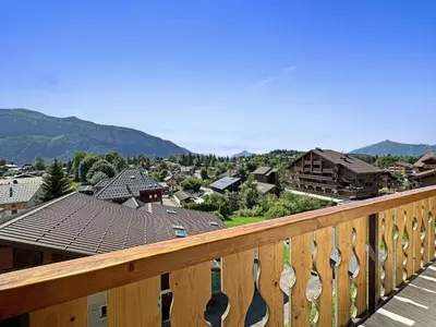 a view of a town from a wooden balcony at GR450 6 Pers Centre Carroz in Les Carroz d'Araches
