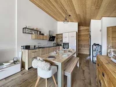 a kitchen with a wooden table and a dining room at GR450 6 Pers Centre Carroz in Les Carroz d'Araches