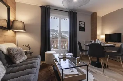 a living room with a couch and a table at Le Farniente - Central - Chaleureux in Megève