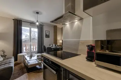 a kitchen with a counter top and a stove top oven at Le Farniente - Central - Chaleureux in Megève