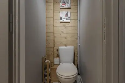 a bathroom with a white toilet in a hallway at Le Farniente - Central - Chaleureux in Megève