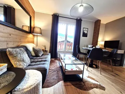 a living room with a couch and a table at Le Farniente - Central - Chaleureux in Megève