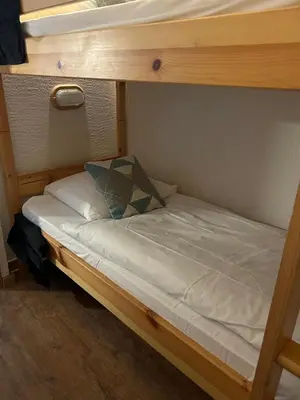 a bunk bed with a pillow on the bottom bunk at Appt MIAGE - 2 pièces cabine, terrasse & piscine in Saint-Gervais-les-Bains