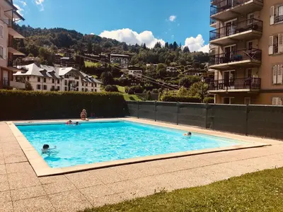 a group of people swimming in a swimming pool at Appt MIAGE - 2 pièces cabine, terrasse & piscine in Saint-Gervais-les-Bains