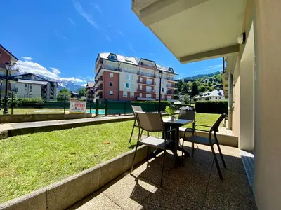 a balcony with a table and chairs and a view at Appt MIAGE - 2 pièces cabine, terrasse & piscine in Saint-Gervais-les-Bains
