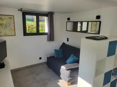 a living room with a couch and a window at Studio Saint Antoine Les Houches in Les Houches