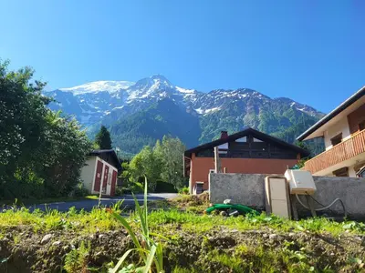 a house with mountains in the background at Studio Saint Antoine Les Houches in Les Houches
