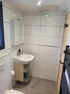 a white bathroom with a sink and a mirror at Studio Saint Antoine Les Houches in Les Houches
