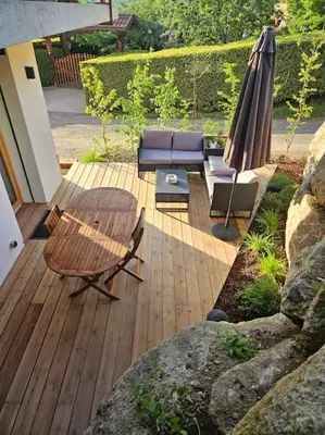 a patio with a table and a couch and an umbrella at Charmant T1 montagnard proche télécabine in Saint-Gervais-les-Bains