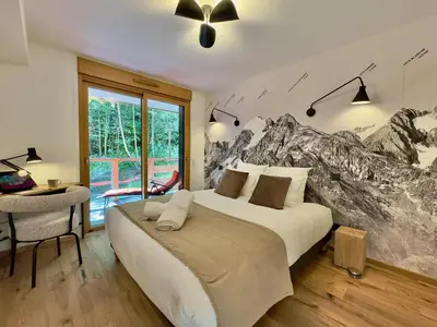 a bedroom with a bed with a mountain mural on the wall at Le lodge de l alpage - Ski in ski out - 2 chambres 1 cabine in Combloux