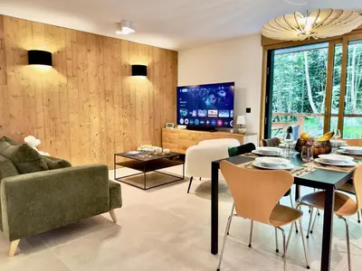 a living room with a couch and a table at Le lodge de l alpage - Ski in ski out - 2 chambres 1 cabine in Combloux