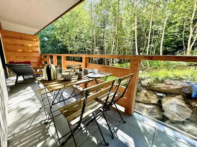 a patio with a table and chairs on a deck at Le lodge de l alpage - Ski in ski out - 2 chambres 1 cabine in Combloux