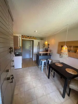a kitchen and a living room with a table in a room at le jaillet in Megève