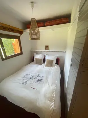 a bedroom with a bed with white sheets and a window at le jaillet in Megève