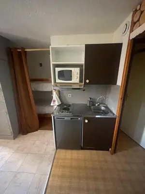 a small kitchen with a microwave and a sink at le jaillet in Megève