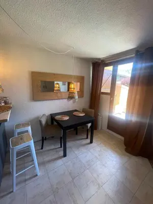 a dining room with a table and a chair at le jaillet in Megève