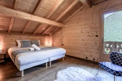 a bedroom with a bed in a log cabin at Balcon De l Europe - Jacuzzi prive - Vues in Les Houches