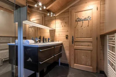 a bathroom with a sink and a wooden wall at Balcon De l Europe - Jacuzzi prive - Vues in Les Houches