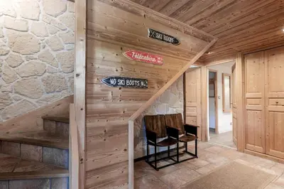 a room with a wooden wall with stairs and a sign at Balcon De l Europe - Jacuzzi prive - Vues in Les Houches